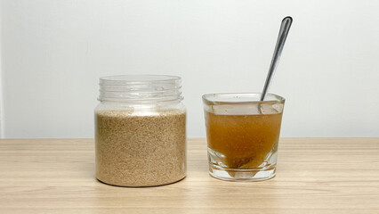 A jar of psyllium husk and a glass of soaked seeds in water on the table. The concept of preparing a natural supplement for gastrointestinal health and daily nutrition. © Lisi4ka