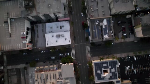 Alternate take of drone flying over downtown San Diego buildings with camera tilting up to reveal harbor and sunset.