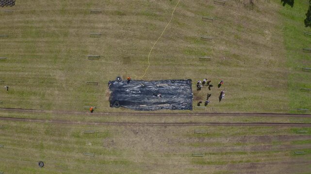 Aerial View of People Sliding on Giant Slip and Slide in Open Field