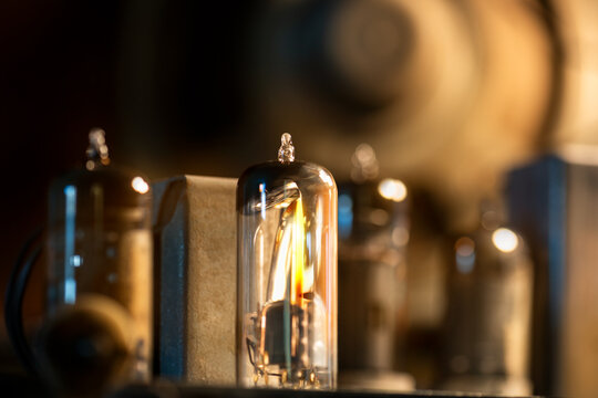 Close-up of a real glowing vacuum tube lamp into an old radio.