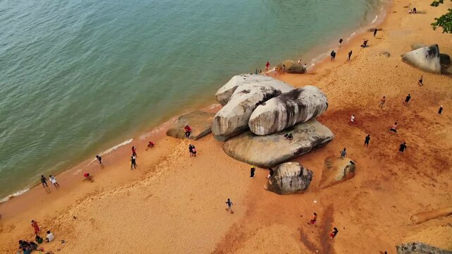 Drone aerial beach with rocks and people on tropical coast