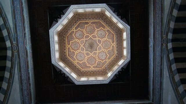 Upward view of ornate dome ceiling with intricate geometric patterns and decorative motifs typical of Islamic architecture. Ceiling of Sultan Al-Ashraf Qaytbay Mosque and Mausoleum, Cairo, Egypt