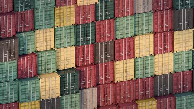 Colorful stacked cargo containers forming a geometric pattern, representing global trade, logistics networks, and industrial supply chain infrastructure. 3D render seamless loop animation