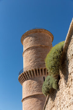 Vue en gros plan sur la tour du fanal du fort Saint-Jean &agrave; l'entr&eacute;e du Vieux-Port de Marseille, v&eacute;g&eacute;tation sur les murs des remparts, beau ciel bleu en arri&egrave;re-plan