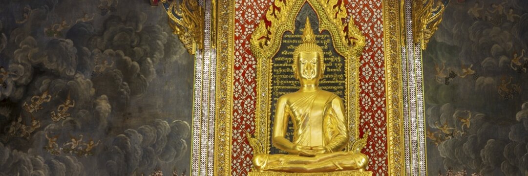 Golden meditating Buddha surrounded by wall paintings with Buddhist teachings and representations of Buddha's disciples, Wat Makut Kasatriyaram Ratchaworavihan, Phra Nakhon District, Old Bangkok, Thailand