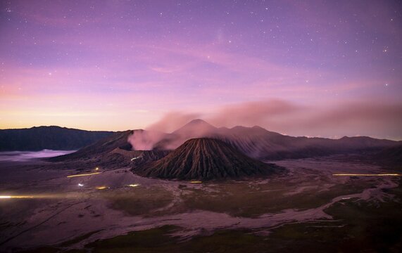 Volcanic landscape at sunrise with starry sky, smoking volcano Gunung Bromo, with Mt. Batok, Mt. Kursi, Mt. Gunung Semeru, National Park Bromo-Tengger-Semeru, Java, Indonesia