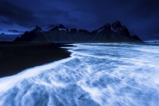 Mountain peaks and surf, blue hour, H&ouml;fn, Iceland