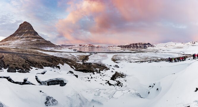 Kirkjufell mountain, Kirkjufellfoss waterfall frozen in front, cloudy sky with sunset, Grundarfj&ouml;rdur fjord, western Iceland, Iceland