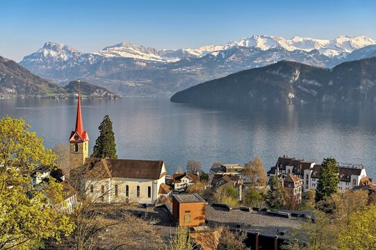 Holiday destination on Lake Lucerne with the parish church of St. Mary behind the snow-covered Alps, Weggis, Canton Lucerne, Switzerland