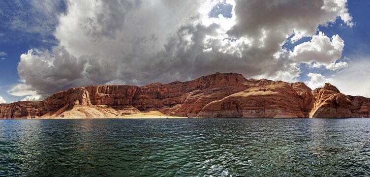 Red Navajo sandstone cliffs, rock formations, rising from Lake Powell, Page, Arizona, USA
