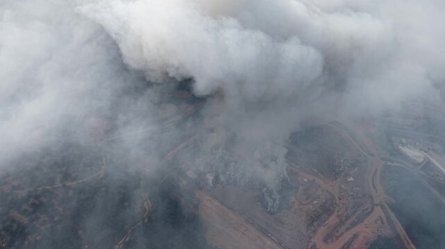Aerial view of landfill site burning with dense smoke
