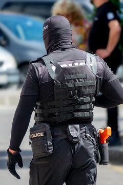 Special police unit officer in full tactical gear, including a balaclava and body armor. Concept of law enforcement, special operations, and urban security.