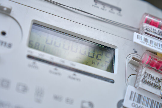 Close up of digital electricity meter with display and security seals. Concept of power consumption utility measurement and household energy monitoring