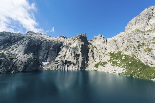 Mountain lake Lac de Melo surrounded by cliffs, source of the Restonica river, Restonica mountain valley, Corte, Haute-Corse, Corsica, France