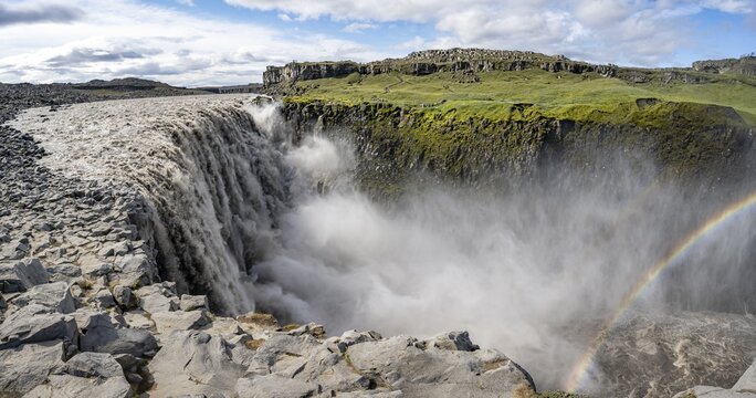 Canyon with falling water masses and rainbow, Dettifoss waterfall in summer, North Iceland, Iceland