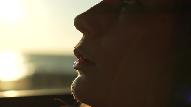 Sunset travel reflection young woman looks out car window at the ocean during golden hour feeling peaceful and calm
