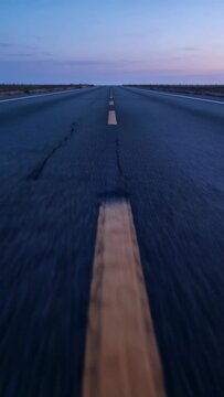 Vertical video: Starting camera capturing road at twilight, showing yellow dashed stripe