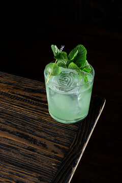 Mint cocktail served in a glass on a wooden table, showing the drink and its details clearly