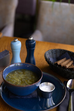 Fresh soup served with bread on a wooden table in a restaurant during lunch hour
