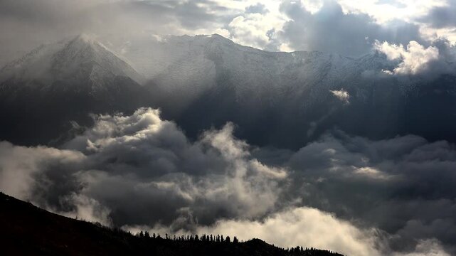Sea of clouds over mountain valley at sunrise with fog, mist, forests, hills, dramatic peaks. Golden dawn haze fills a highland basin as vapor drifts through woodland slopes beneath towering summits.