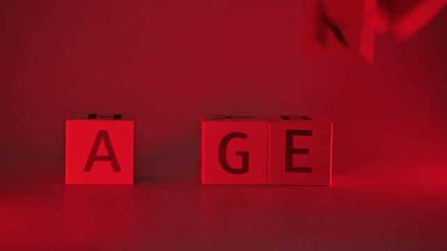 A hand moves letter blocks to form words related to strong emotions under red lighting. The focus is on a simple arrangement of letters that convey feelings such as anger and rage