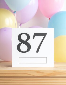 Birthday card with number 87 and text box for name or message. Pastel colors and balloons