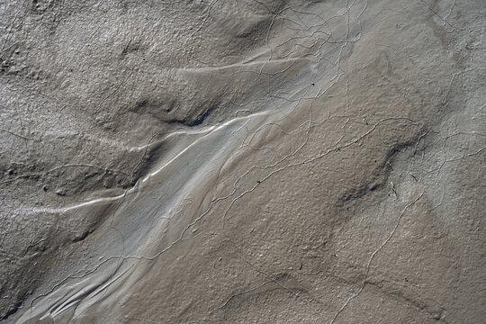 Abstract Nature Background Texture of Wet Grey Mud with Fine Cracks, Close Up Minimalist Top View of Textured Slime Clay and Earth Soil Pattern formed by Water Flow
