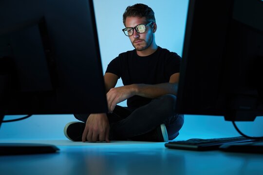 Young Man Working Between Two Monitors