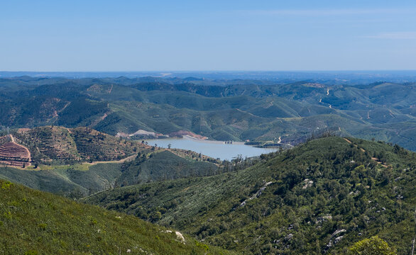 Lake with trees and a hill formation on the horizon.