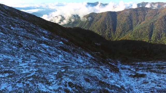 Aerial view of fresh snow covering a sharp mountain ridge in the Peruvian Andes at high altitude. Winter snowfall, rugged peaks, and alpine landscape depict rugged regional geology.