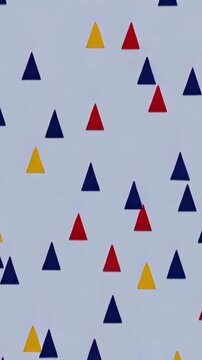 Vertical video: Loop starting, triangles in navy red yellow scrolling up on gray screen as backdrop