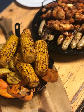 Delicious barbecue feast: grilled corn, potatoes, carrots, sausage and chicken. Perfect f