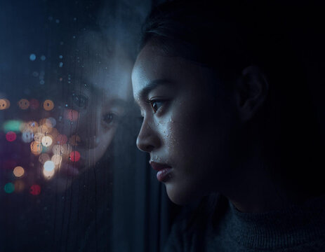 Woman looking out window at night.