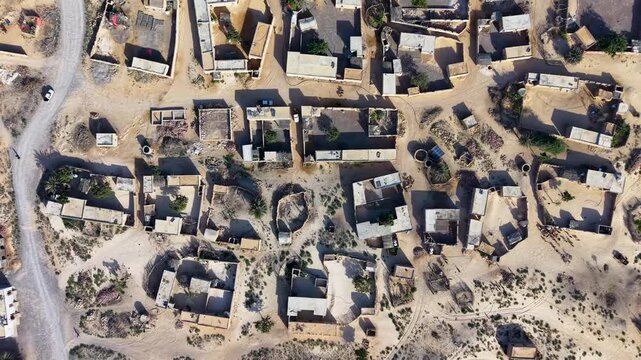 Aerial view of desert village with scattered houses and roads