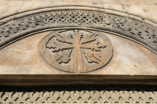Intricate stone carving of an armenian cross symbol on an ancient monastery wall, depicting religious faith, historical art, and spiritual heritage in armenia