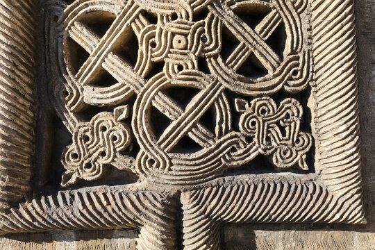 Armenian cross stone intricate stone carving featuring ancient geometric patterns and symbols, traditional medieval religious relief artwork detailed on a historic khachkar monument