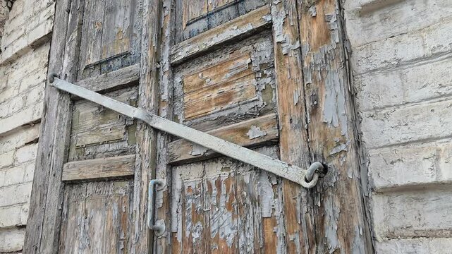 A shuttered window of an abandoned dilapidated house