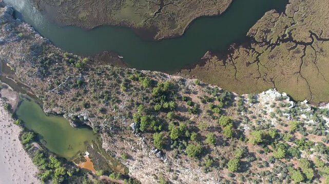 Aerial view of reeds river channels in a coastal delta beside a long sandy beach in Turkey. Summer season, south america, aegean coast, and coastline convey resort tourism appeal.