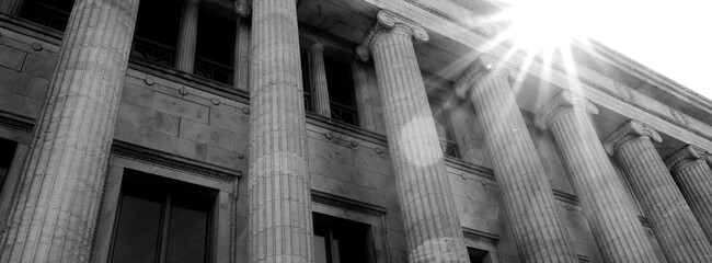 Naklejka premium Columns on Old Building with Sunstar or Sunshine on Architecture and Design Library Courthouse or Government Building