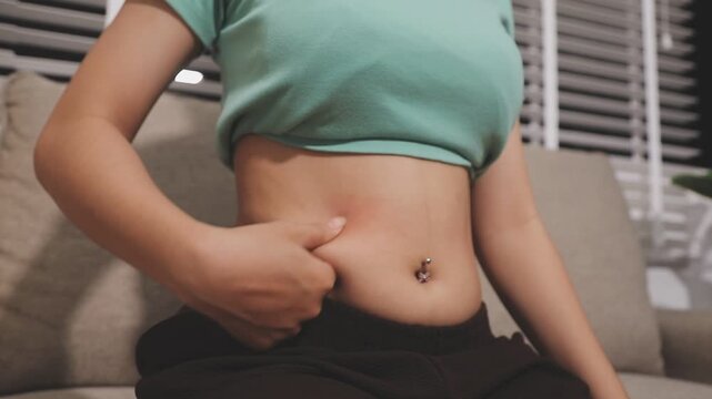fat woman, fat belly, chubby, obese woman hand holding excessive belly fat with measure tape, woman diet lifestyle concept