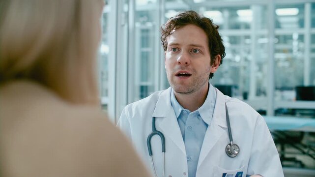 Woman filling out patient registration form, giving document to male doctor and listening to his advice during medical consultation in clinic. Tilt up shot