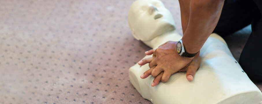 CPR training using and an AED and bag mask valve on an adult training manikin.  First aid cardiopulmonary resuscitation course using automated external defibrillator device, AED.