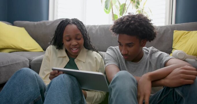 Teenage Friends looking at Digital tablet doing Homework