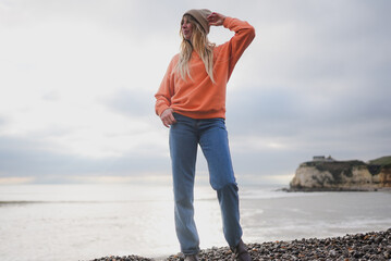 Woman stands on rocky shore, gazing toward sea © Reuben