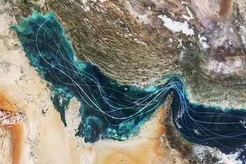Satellite view of the Persian Gulf and Strait of Hormuz with glowing blue lines symbolizing naval traffic and strategic maritime routes amidst geopolitical tensions and regional conflict in Iran.
