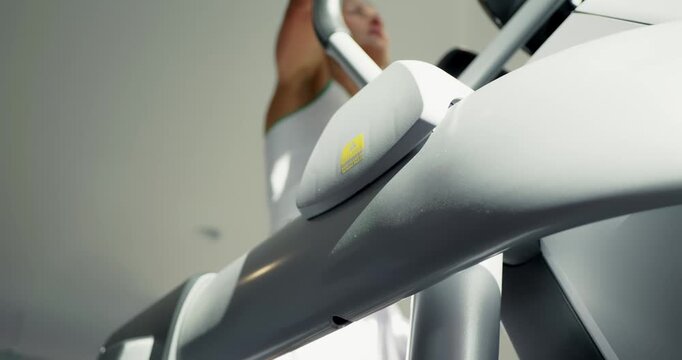 Woman Exercising on Elliptical Machine at Gym