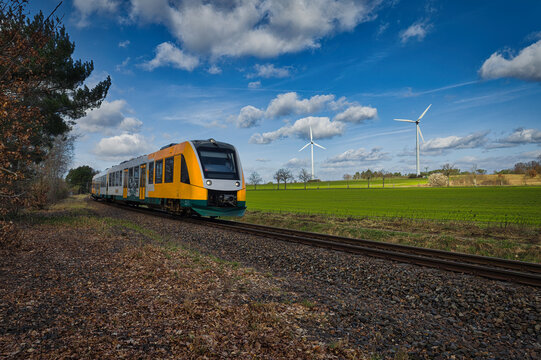 Modern Regional Train Passing Green Field with Wind Turbines - Sustainable Public Transportation Concept - real photography - authentic - no ai - Green Economy