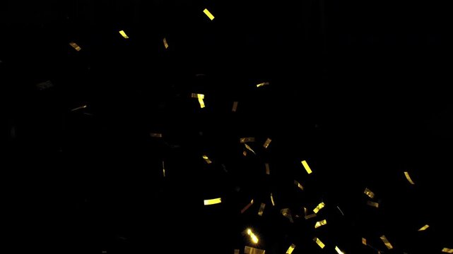 Super slow motion of flying confetti isolated on black background. Filmed on high speed cinema camera