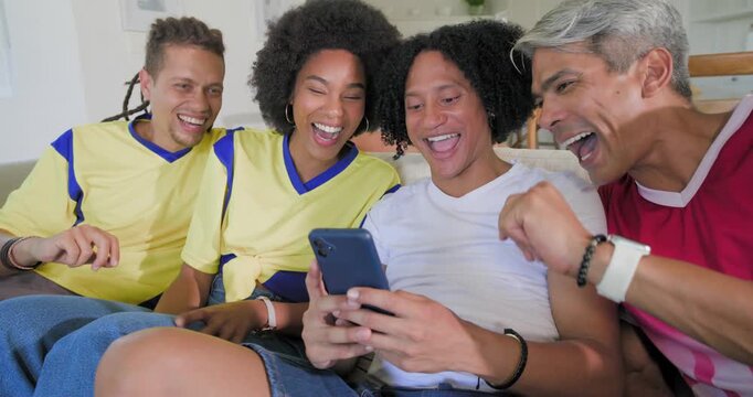 Vertical video: African American friends leaning on sofa center holding phone sharing clip laughing