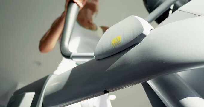 Woman Exercising on Elliptical Machine at Gym